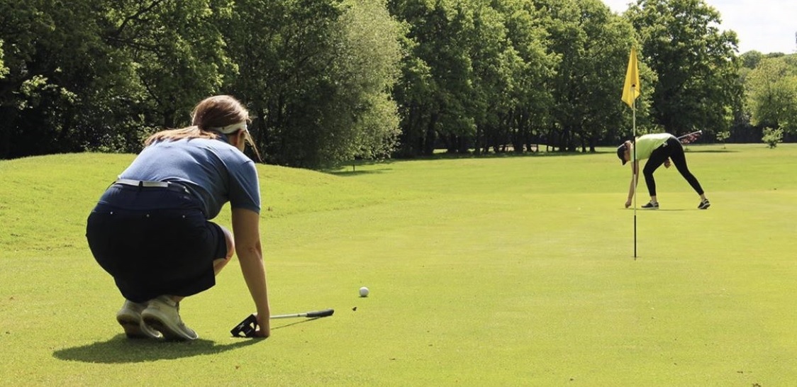 Lady putting on a golf course